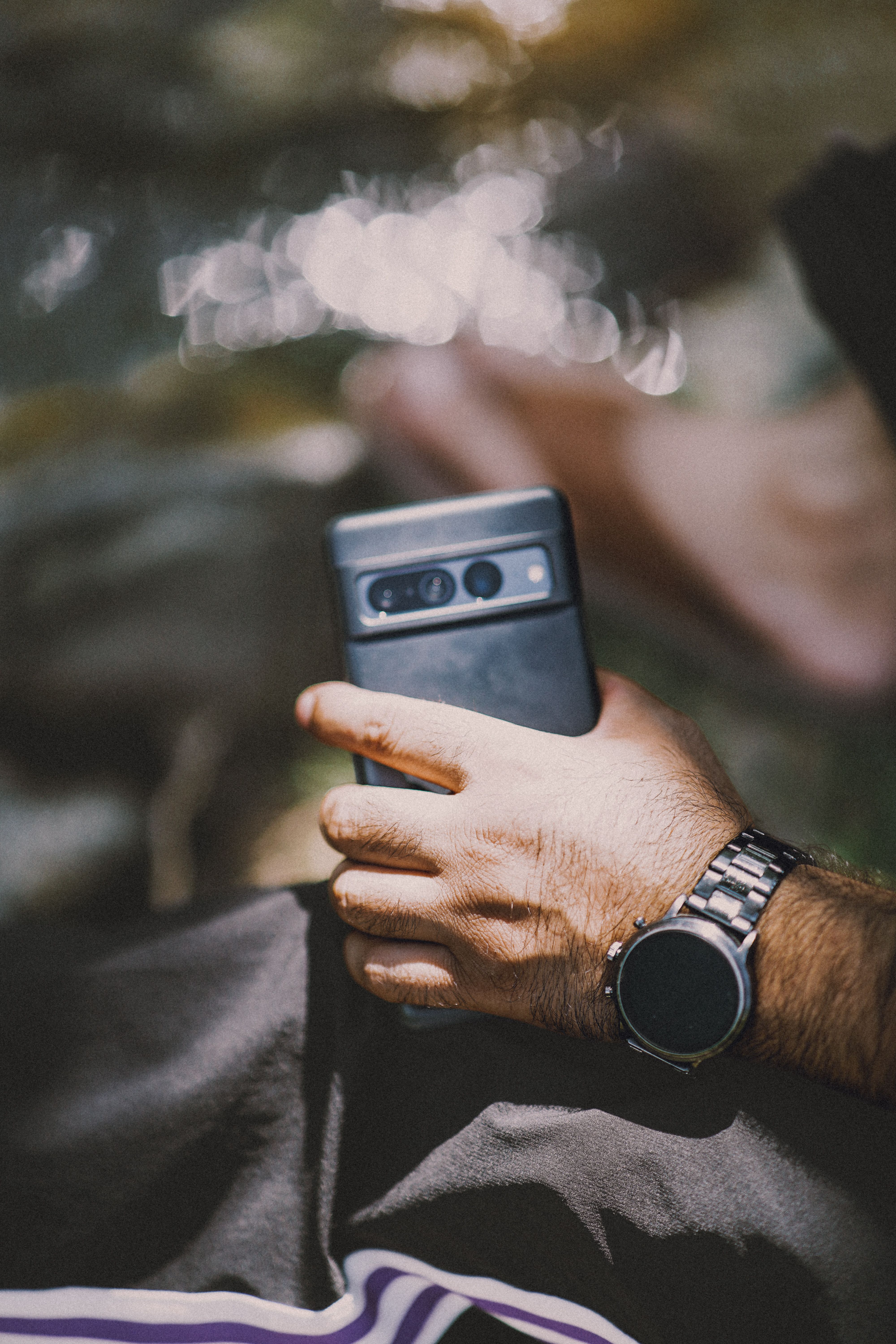 Man checking a smartwatch while holding a smartphone