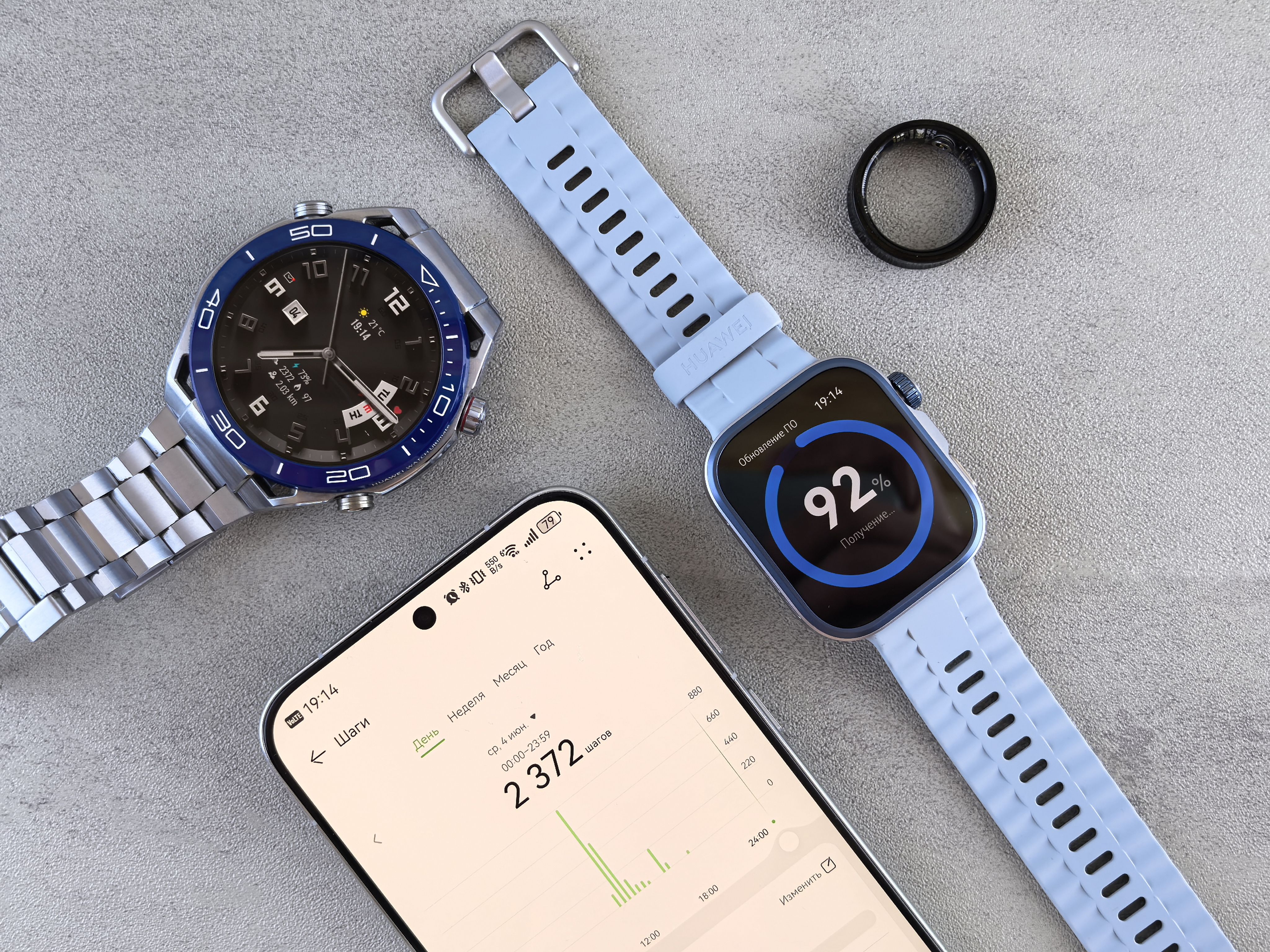 Smartwatch, ring tracker, and smartphone displaying fitness data